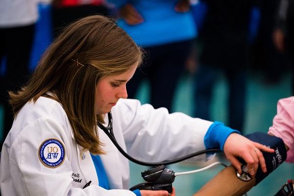 An OUWB student takes someone's blood pressure at the annual Health Fair and Taste Test